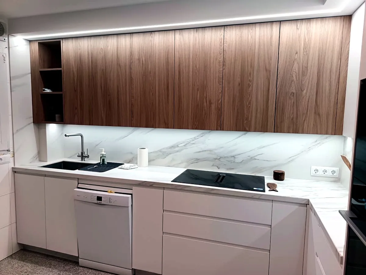 Cocina en L con isla y campana de obra revestida en madera