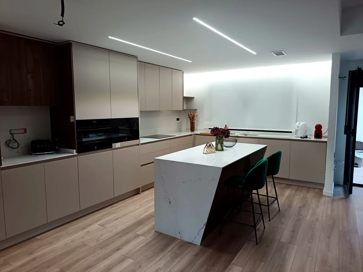 Cocina en tonos taupe con isla en mármol y madera