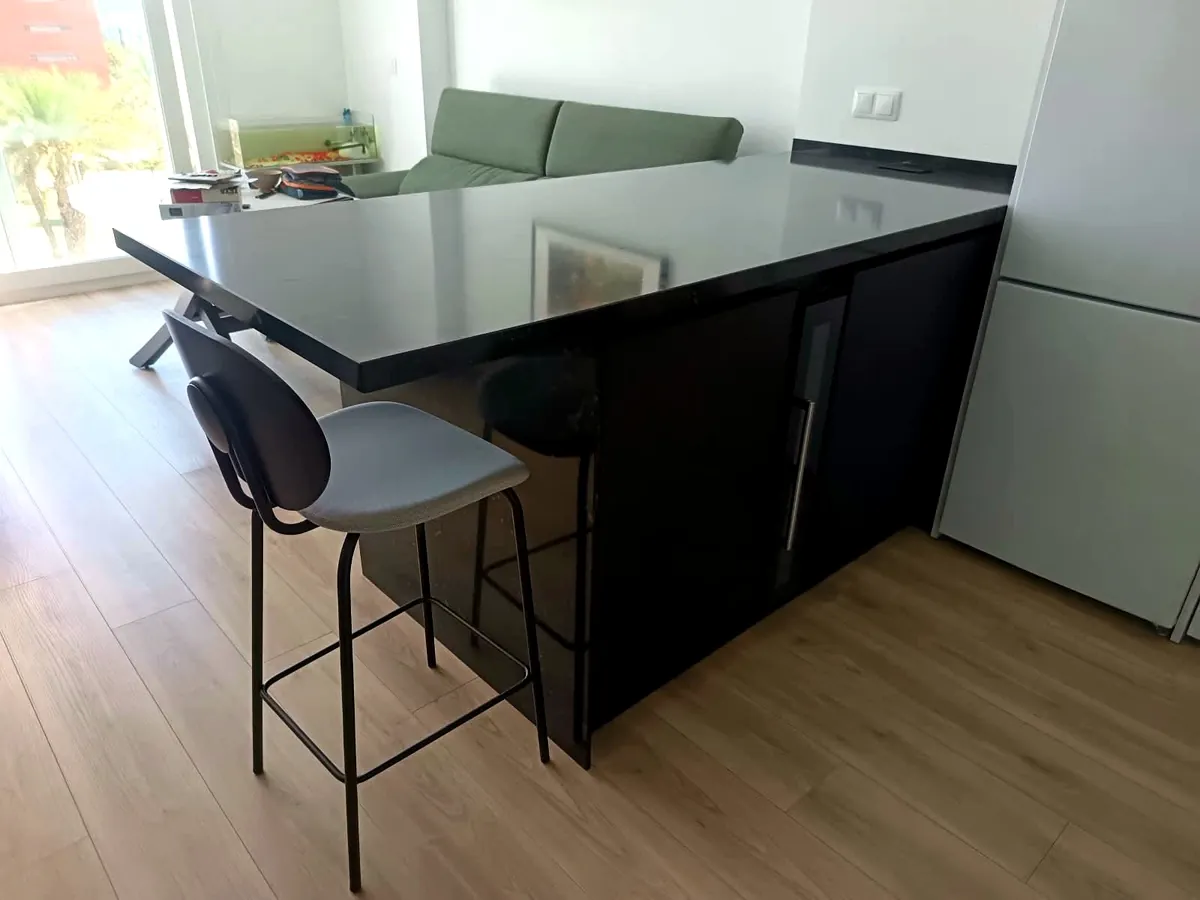 Isla en piedra negra con mueble bar y vinoteca